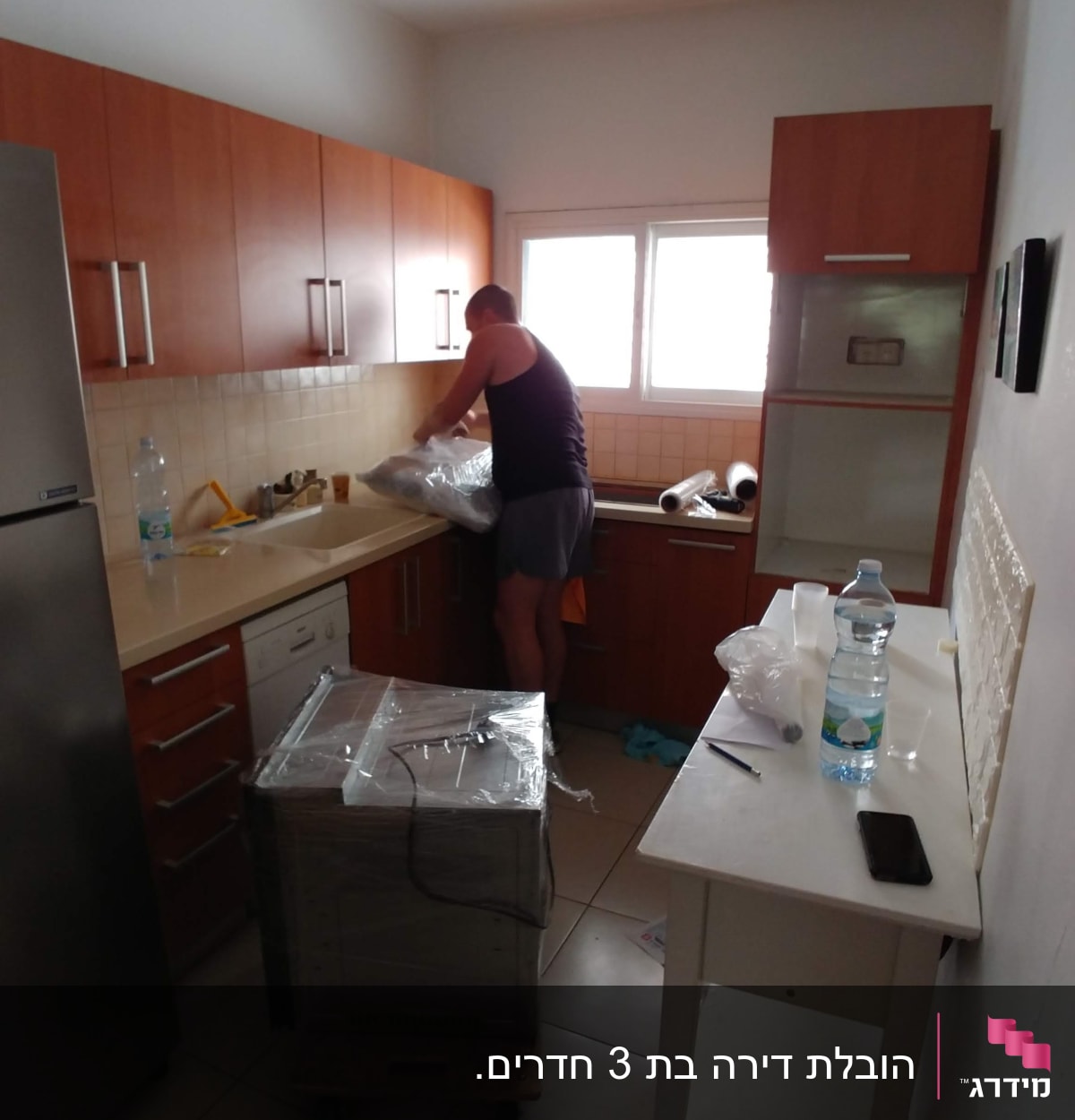 אדם אורז חפצים במטבח לקראת מעבר דירה